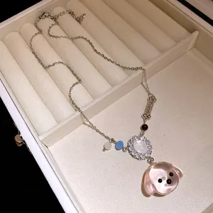Dettaglio della collana con ciondolo a forma di cucciolo in resina rosa e osso con zirconi