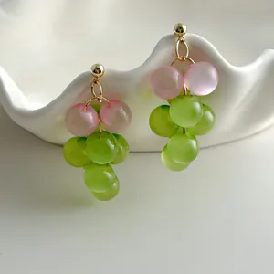 Detail view of fresh grape-shaped earrings with translucent pink and green beads