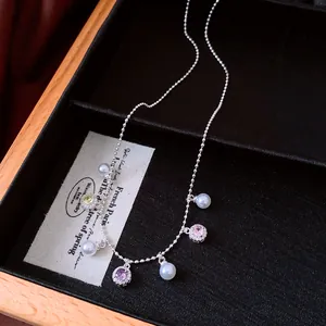 Close-up of elegant silver necklace with pearls and multi-colored gemstone charms