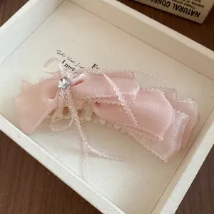 Detail view of pink satin bow hair banana clip with clear bead strings and rhinestone