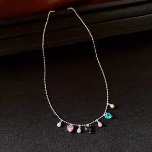 Detailed shot of a vintage necklace with multi-colored heart and bead charms on a silver chain