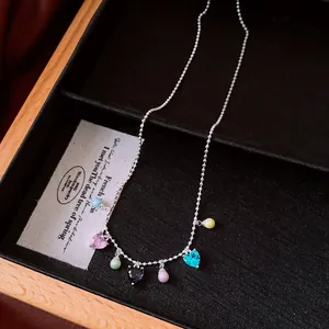 Detailed macro view of a vintage silver necklace with colorful heart and bead charms.