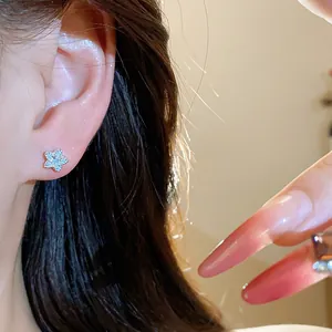Detailed close-up view of a sparkling zircon star stud earring worn on a female ear.