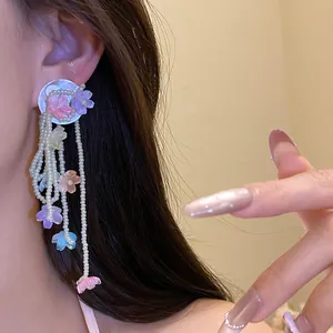 Detailed close-up view of elegant shell flower tassel earrings featuring white bead strands