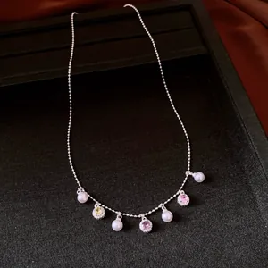 Detailed close-up of a silver necklace featuring pearls and colorful gemstone charms