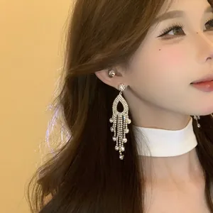 Detailed close-up of sparkling crystal tassel drop earrings worn by an elegant Asian model