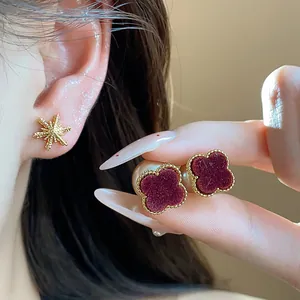 Close-up detail of 18k gold plated red velvet four-leaf clover earrings with pearl backings