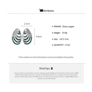 Detailed view of luxury multi-layer spiral earrings featuring emerald green zircons.