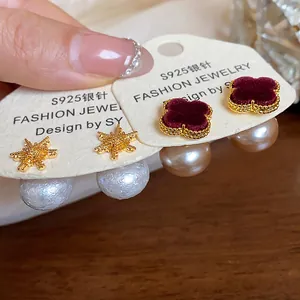 Detailed view of 18k gold plated flower and pearl stud earrings with S925 silver needles