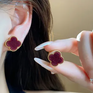 Detailed macro view of vintage red velvet clover earrings with gold beaded borders