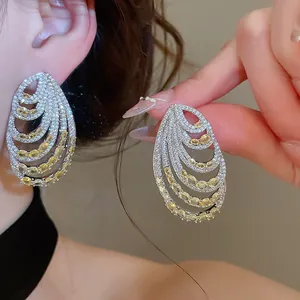 Macro detail view of elegant multi-layered thread earrings with yellow and white zircons