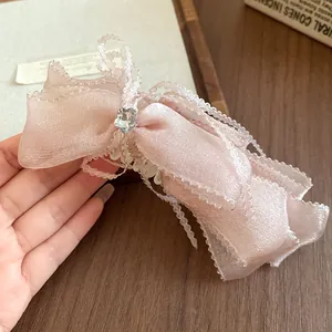 Close-up of pink bow hair clip with delicate lace edges and star rhinestone detail