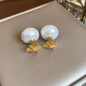 Close-up of vintage pearl earrings with gold flower base and textured white pearls