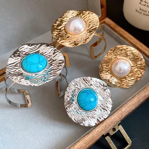 Vintage hammered metal jewelry set with turquoise and pearl accents shown in a box
