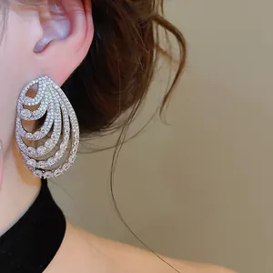 Close-up of elegant multi-layered silver spiral earrings with sparkling zircon stones.