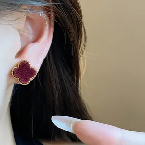 Detailed close-up view of vintage four-leaf clover stud earring with golden beaded edge