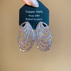 Detailed macro shot of multi-layer silver earrings with pink and white cubic zirconia crystals