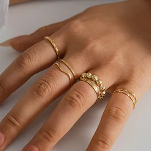 Detailed close-up shot of an eight-piece stackable gold geometric ring set on a hand