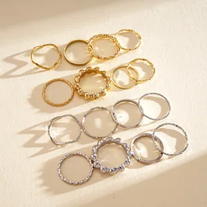 Close-up of minimalist geometric metal ring set showing gold and silver assorted designs