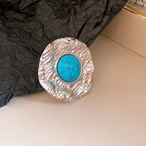 Macro view of a vintage pleated silver ring with a vibrant round turquoise stone