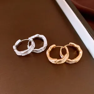 Macro detail of textured 18k gold and silver plated wrinkled vintage hoop earrings.