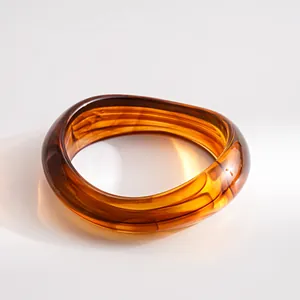 Close-up of a vintage amber resin wavy bangle bracelet with a glossy finish.