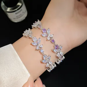 Detailed close-up of a silver floral bracelet with purple and clear zircon stones on a wrist