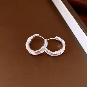 Macro shot of textured silver pleated round hoop earrings showing vintage details