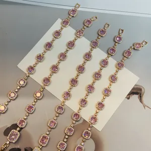 Λεπτομέρεια από vintage επιχρυσωμένα βραχιόλια 18k με λαμπερά ροζ τετράγωνα ζιργκόν.