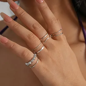 Detail view of 8-piece minimalist silver geometric ring set worn on hand.