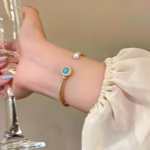 Elegant 18k gold plated open cuff bracelet with pearl and turquoise accents on wrist