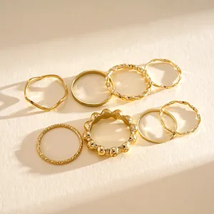Collection of 8 minimalist gold geometric rings with textured and twisted designs
