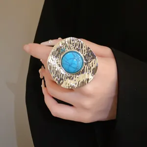 Close-up detail of a vintage hammered metal open ring with blue turquoise stone inlay