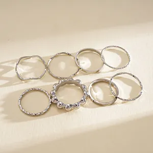 Macro view of minimalist 8-piece silver geometric ring set featuring varied textures