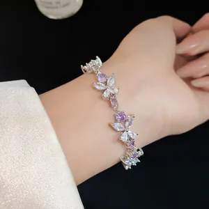 Close-up of French style silver flower bracelet with purple and clear zircons on wrist.
