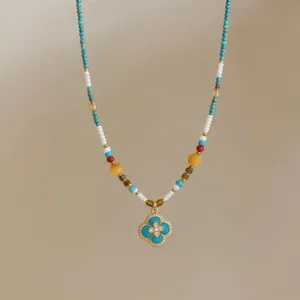 Detail of 18k gold-plated beads necklace featuring a zircon four-leaf clover pendant.