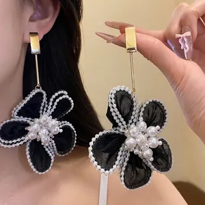 Elegant black gauze flower dangle earrings featuring pearl clusters and a gold link.
