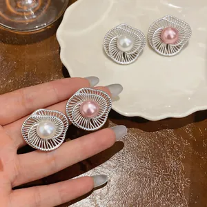 Elegant silver hollow flower stud earrings with white and pink pearls close-up view