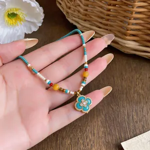 Close-up of bohemian beaded necklace with clover pendant and zircon inlay
