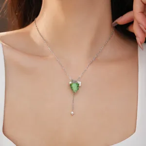 Detail of a green resin grape pendant necklace with pearls on an Asian model