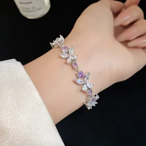 Detailed view of elegant zircon flower bracelet with purple and white stones on wrist.