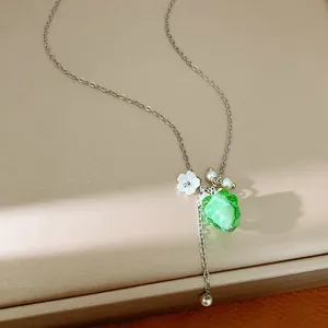 Detailed shot of green resin grape and white flower charms on silver necklace