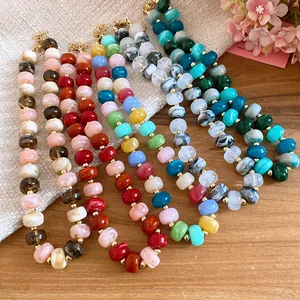 Detailed view of colorful handmade beaded necklaces with varied marble patterns and hues.