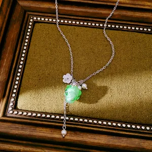 Close-up of elegant resin grape pendant necklace with dainty white flower and pearls