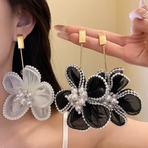Close-up of oversized mesh flower dangle earrings with pearl accents on Asian model