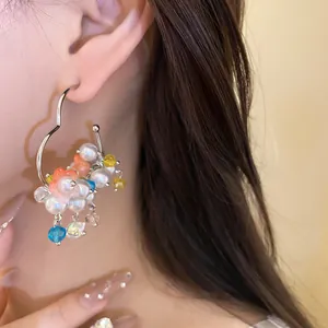 Detailed close-up view of elegant pearl and flower dangle earring worn on the ear