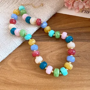 Colorful handmade beaded necklace with vibrant geometric stones and golden accents.