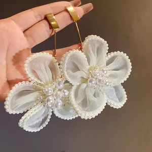 Detailed close-up of elegant snow gauze flower drop earrings with white pearl clusters