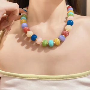 Detailed close-up view of a colorful handmade beaded geometric necklace on a model.