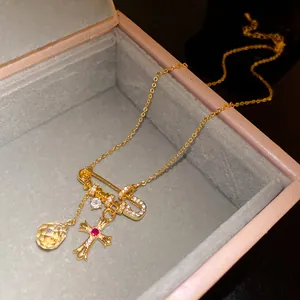 Gros plan d'un collier plaqué or 18k avec pendentifs croix gothique et fer à cheval